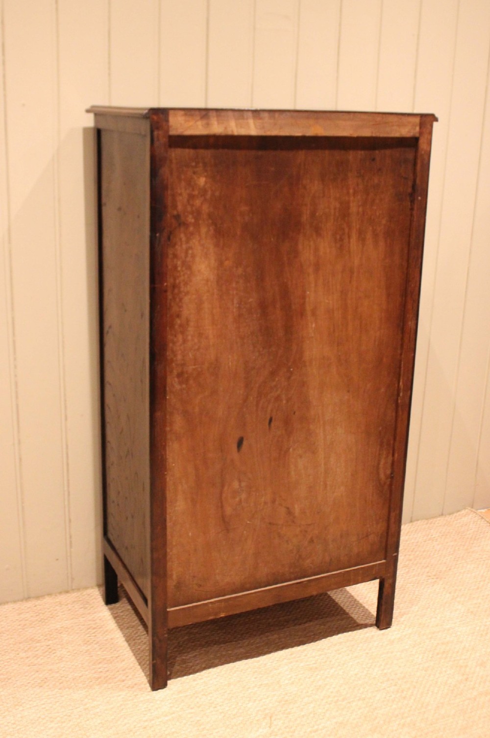 A tall dark oak chest with six stacked drawers and brass cup handles. View XIII