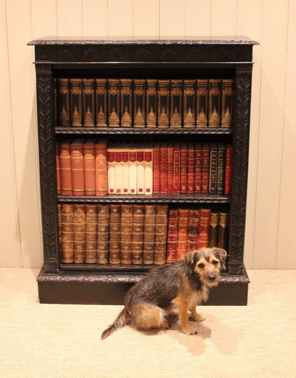 A mid-Victorian dark oak open bookcase featuring hand-carved leaf mouldings and three open shelves filled with antique books. View XI