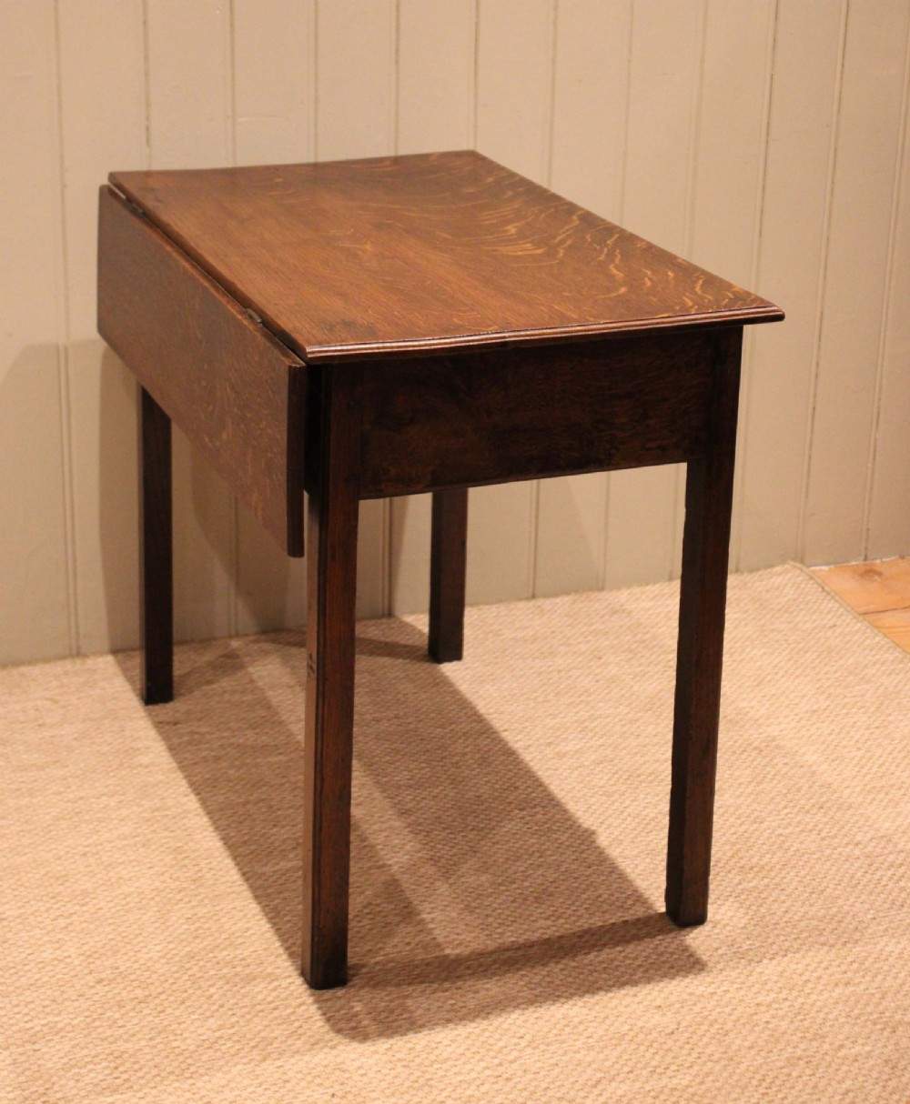 A George III oak side table with a frieze drawer, brass drop handles, a keyhole escutcheon, and straight square legs. View VIII
