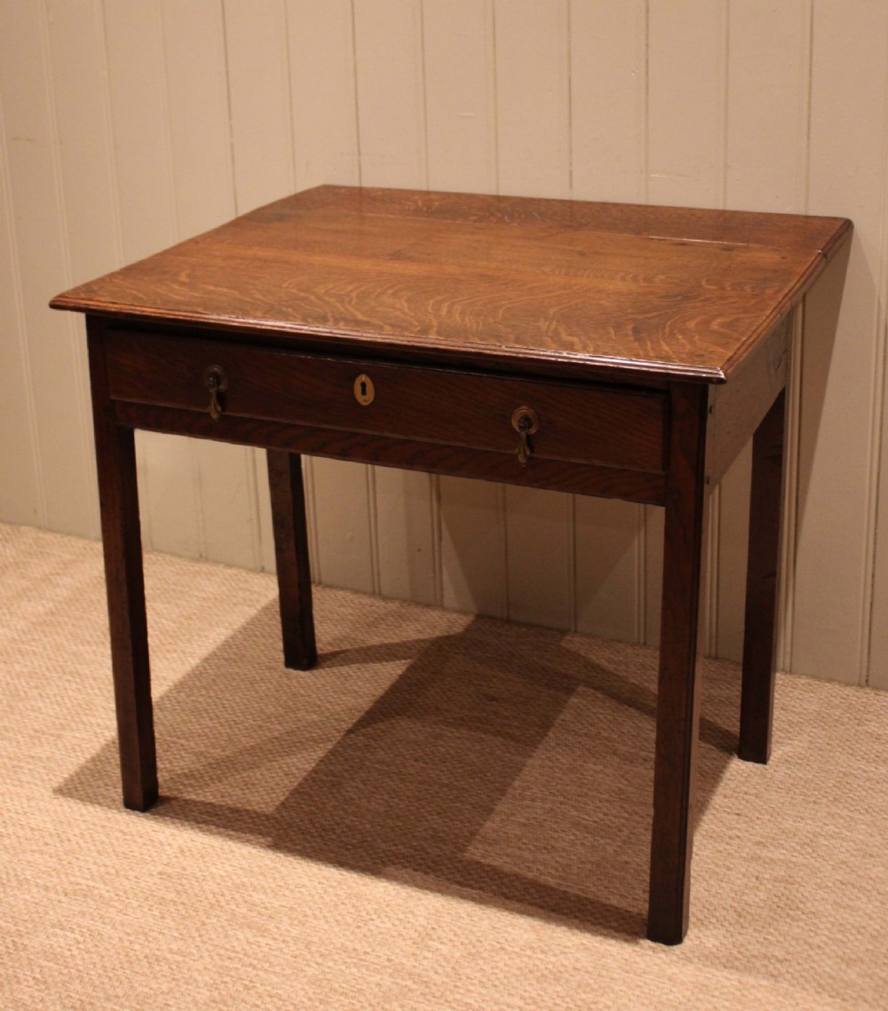 A George III oak side table with a frieze drawer, brass drop handles, a keyhole escutcheon, and straight square legs. View XII
