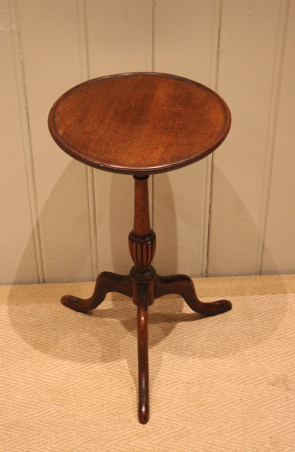 A mahogany wine table featuring a circular dished top supported by a turned reeded pedestal on three splayed cabriole legs.