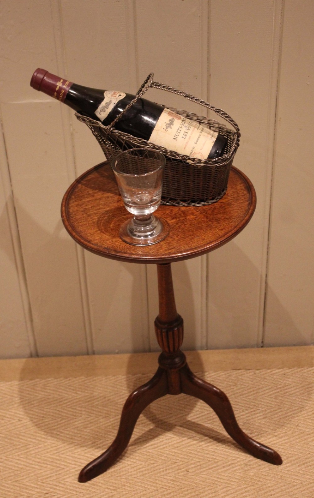 A mahogany wine table featuring a circular dished top supported by a turned reeded pedestal on three splayed cabriole legs. View II