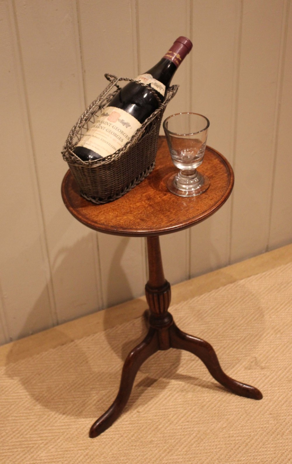 A mahogany wine table featuring a circular dished top supported by a turned reeded pedestal on three splayed cabriole legs. View VI