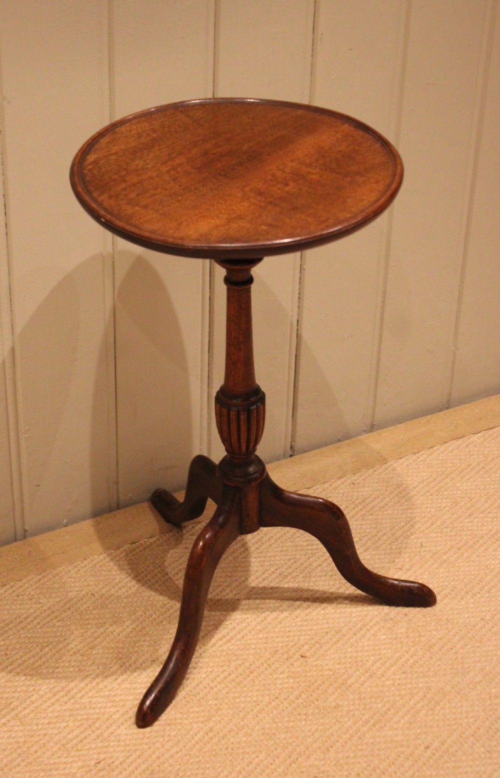 A mahogany wine table featuring a circular dished top supported by a turned reeded pedestal on three splayed cabriole legs. View XI