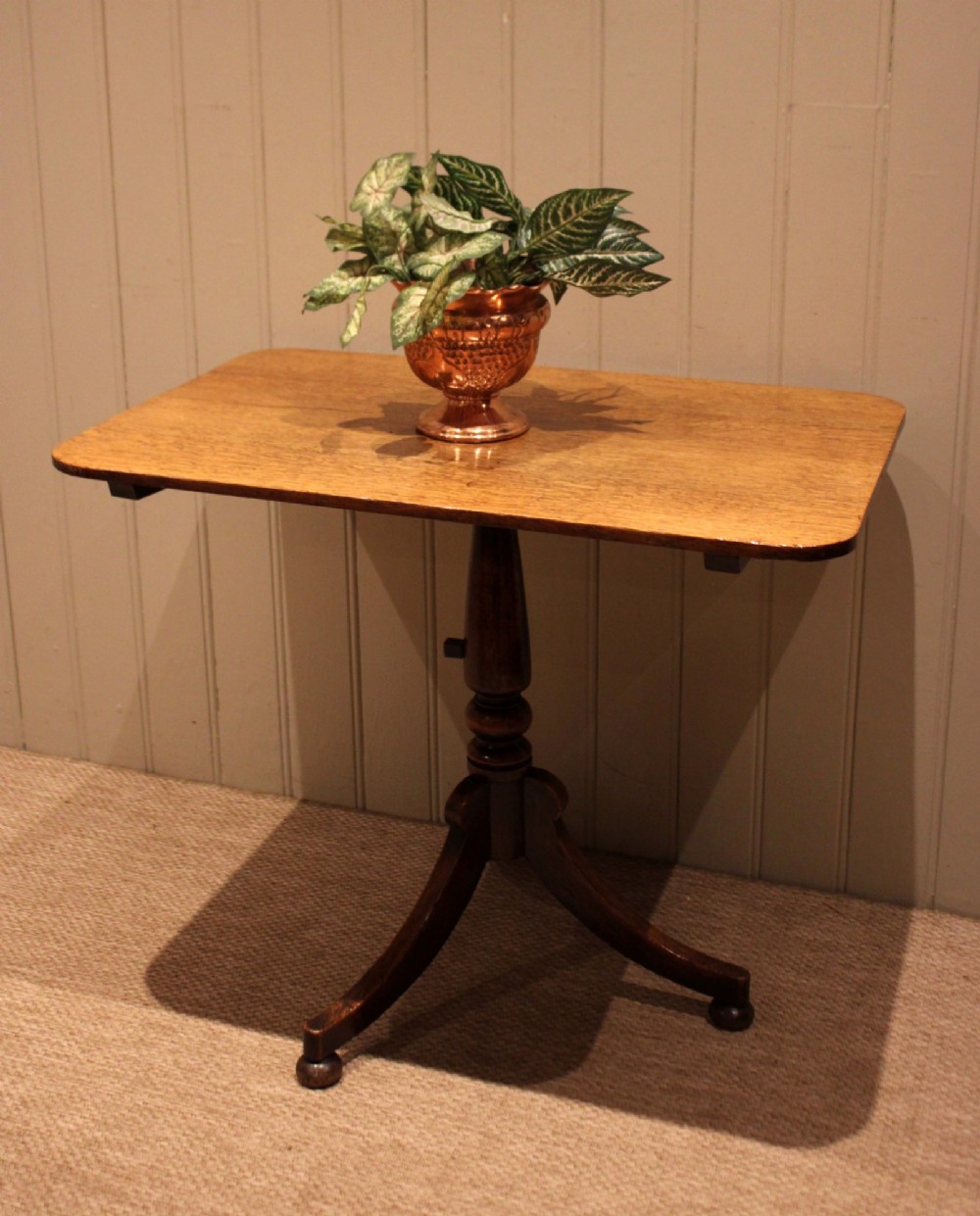 A late Georgian oak tilt-top table featuring a rectangular top with rounded corners, supported by a turned central column and a tripod base. View III