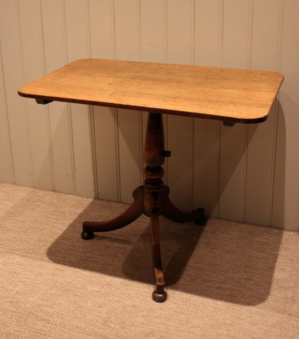 A late Georgian oak tilt-top table featuring a rectangular top with rounded corners, supported by a turned central column and a tripod base. View VIII