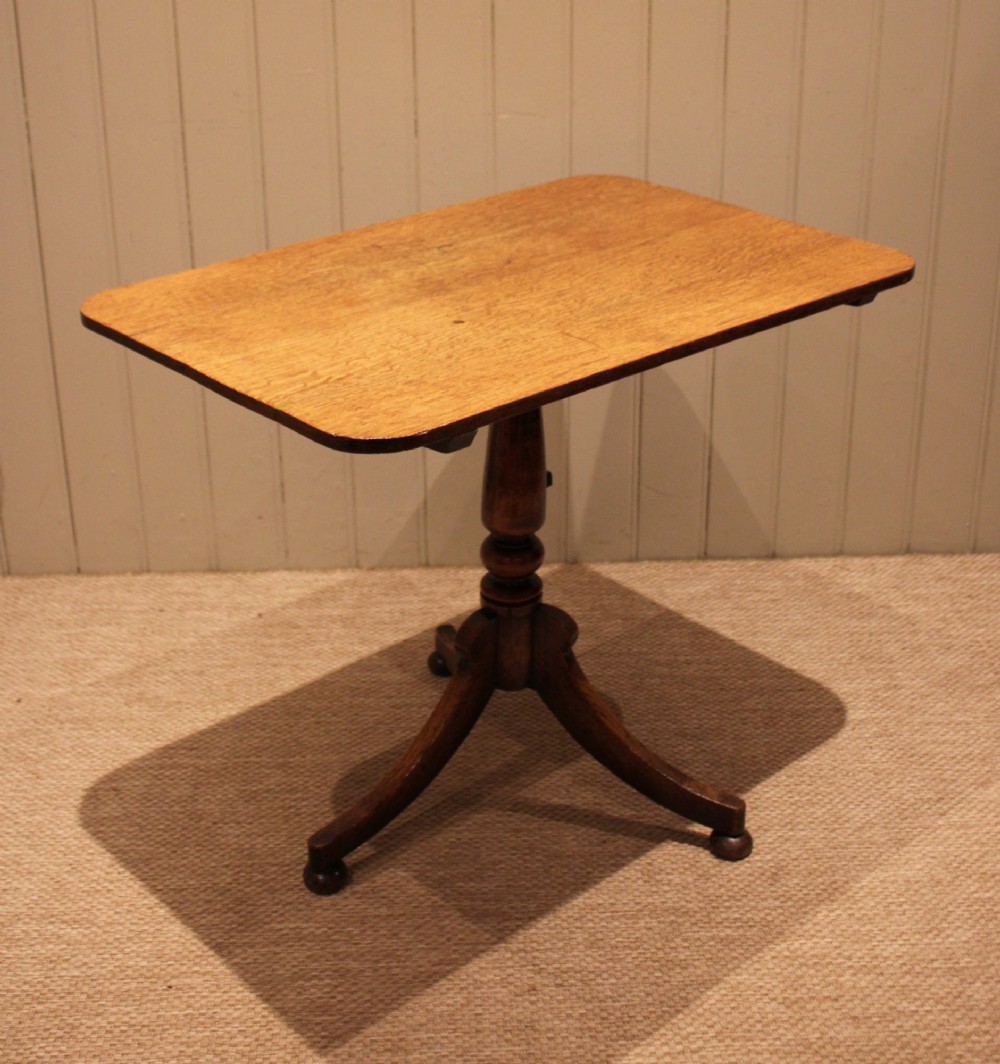A late Georgian oak tilt-top table featuring a rectangular top with rounded corners, supported by a turned central column and a tripod base. View IX