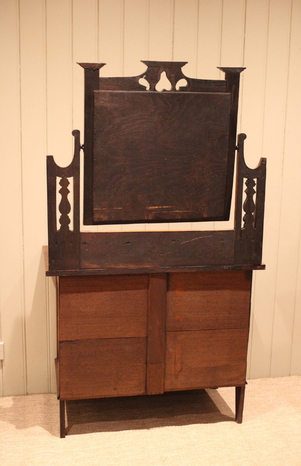 A solid oak Arts and Crafts dressing chest featuring three wide drawers, metal drop handles, heart-shaped cutouts, and a tilting rectangular mirror on top. View XII