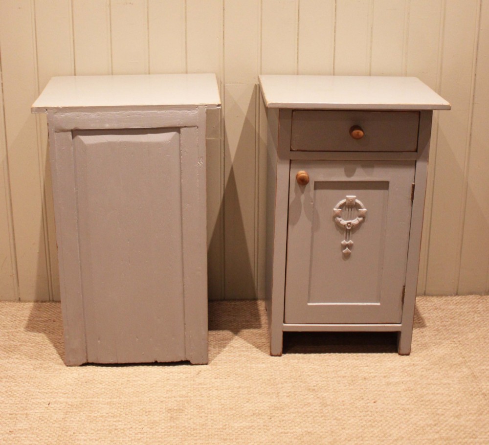 A pair of light grey painted pine bedside cabinets, each featuring a single upper drawer above a cupboard door decorated with a carved wreath motif. View XII