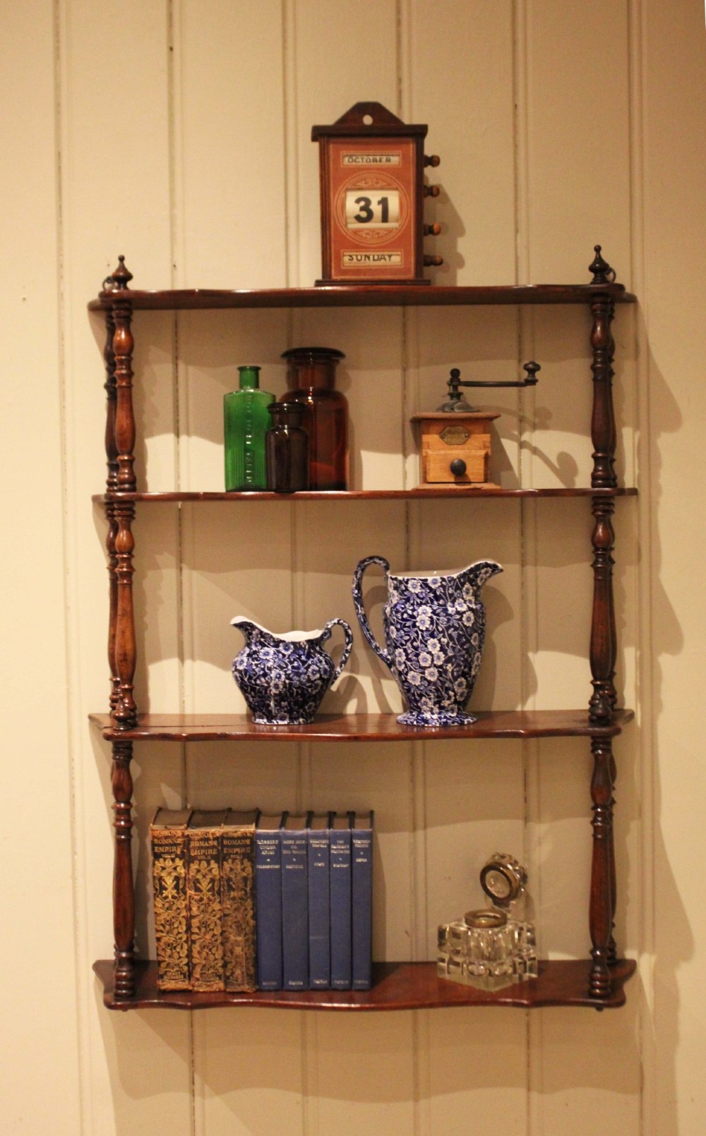 A four-tier late nineteenth-century French mahogany wall shelf unit with turned spindle supports and shaped shelf fronts. View V