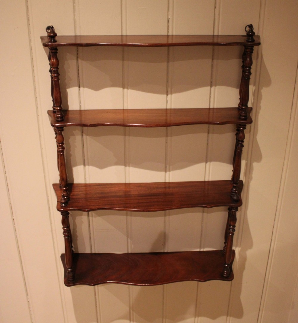 A four-tier late nineteenth-century French mahogany wall shelf unit with turned spindle supports and shaped shelf fronts. View VI
