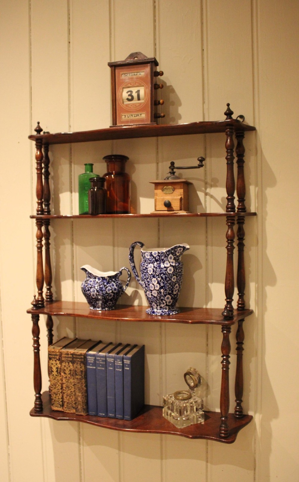 A four-tier late nineteenth-century French mahogany wall shelf unit with turned spindle supports and shaped shelf fronts. View VII