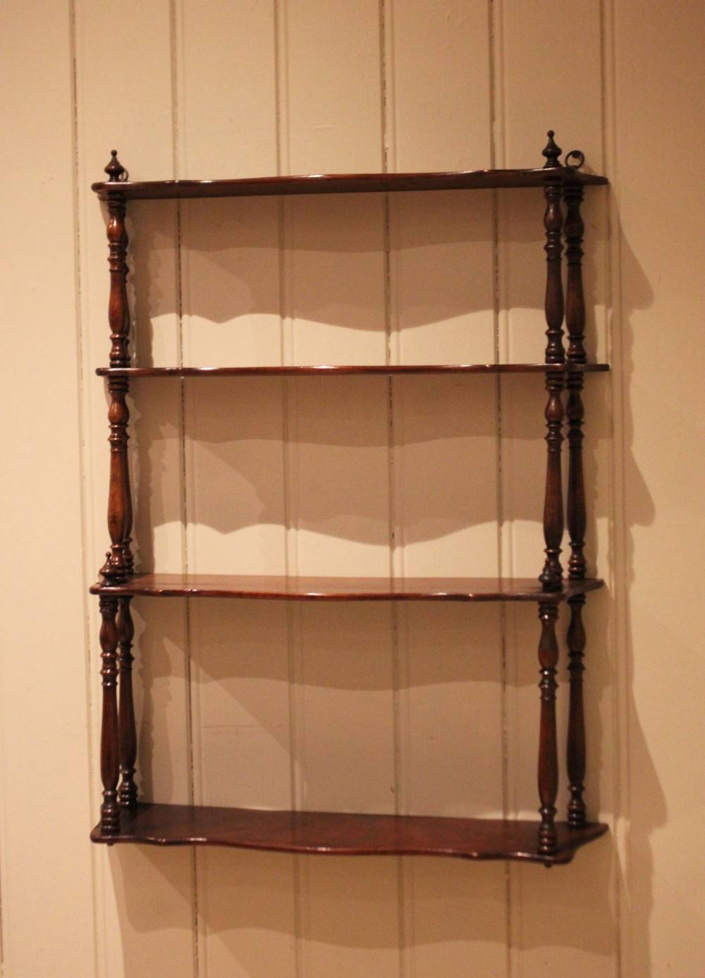 A four-tier late nineteenth-century French mahogany wall shelf unit with turned spindle supports and shaped shelf fronts. View VIII