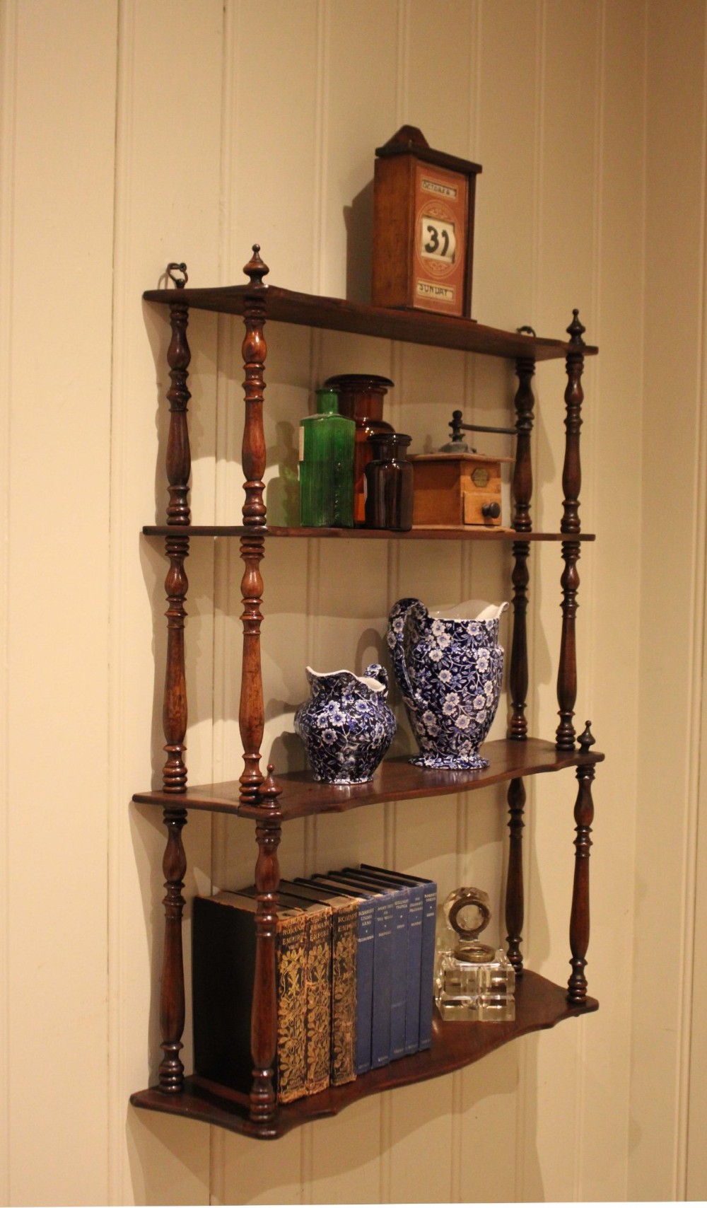 A four-tier late nineteenth-century French mahogany wall shelf unit with turned spindle supports and shaped shelf fronts. View IX
