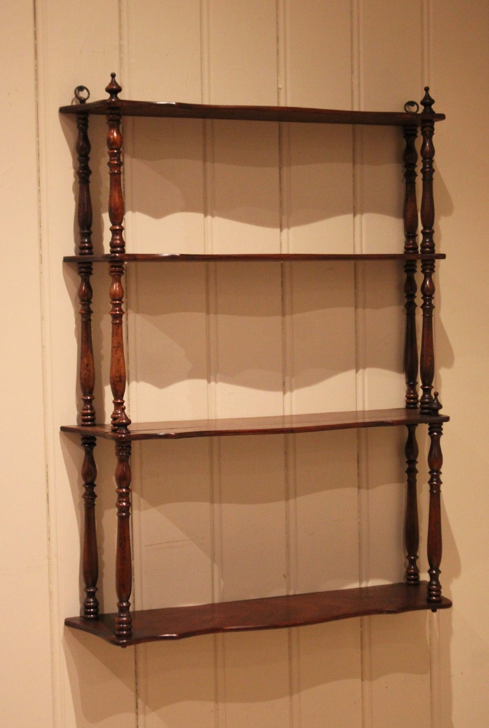 A four-tier late nineteenth-century French mahogany wall shelf unit with turned spindle supports and shaped shelf fronts. View X