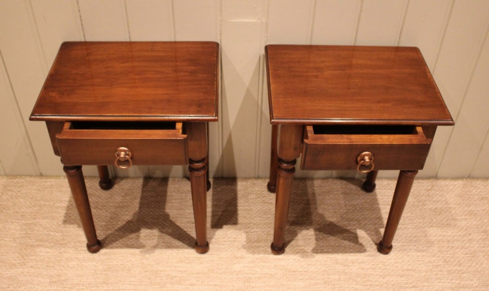 A pair of warm brown French cherry wood bedside tables featuring single drawers with brass ring pulls and slender turned legs. View III