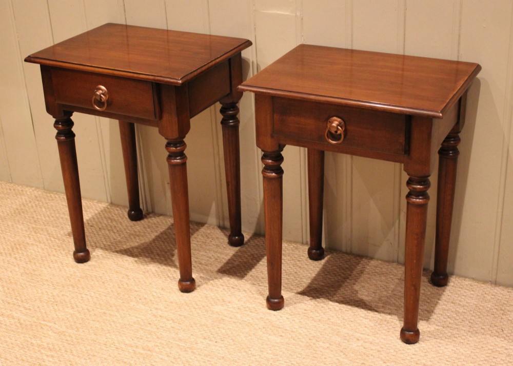 A pair of warm brown French cherry wood bedside tables featuring single drawers with brass ring pulls and slender turned legs. View VII