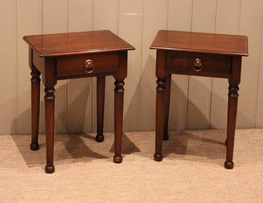 A pair of warm brown French cherry wood bedside tables featuring single drawers with brass ring pulls and slender turned legs. View XI