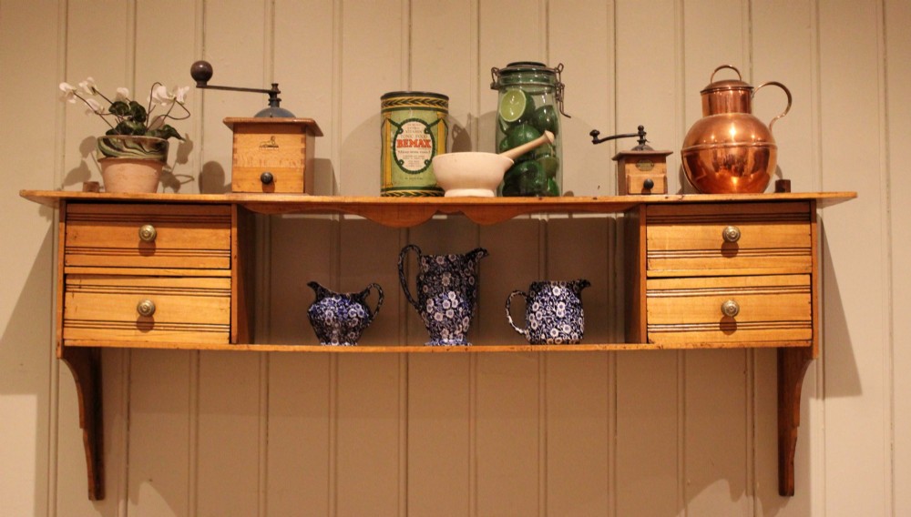 A French poplar wooden wall shelf featuring four side drawers, a central open compartment, and carved lower wall brackets. View II