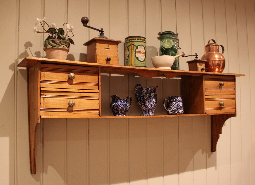 A French poplar wooden wall shelf featuring four side drawers, a central open compartment, and carved lower wall brackets. View III