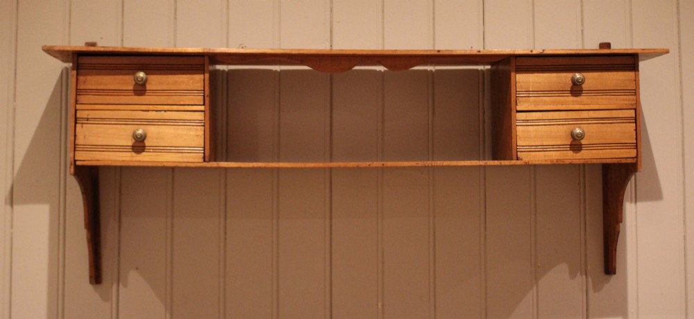 A French poplar wooden wall shelf featuring four side drawers, a central open compartment, and carved lower wall brackets. View IV