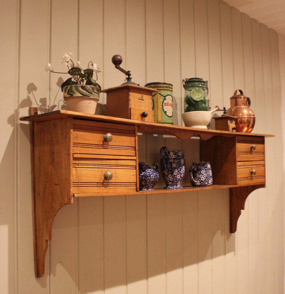 A French poplar wooden wall shelf featuring four side drawers, a central open compartment, and carved lower wall brackets. View IX