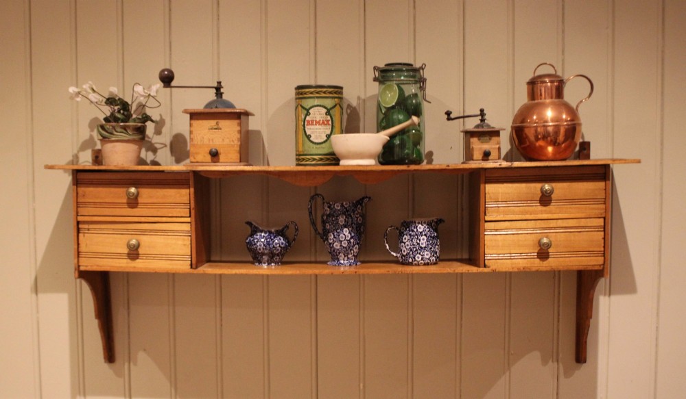 A French poplar wooden wall shelf featuring four side drawers, a central open compartment, and carved lower wall brackets. View X