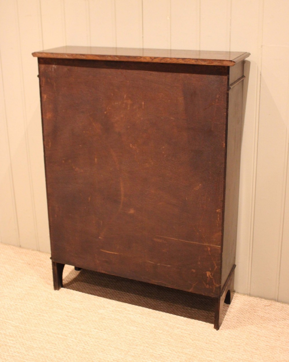 A dark oak open bookcase featuring three adjustable shelves, beaded moulding along the side columns, and a decorative shaped bottom apron with a central circular boss. View XII
