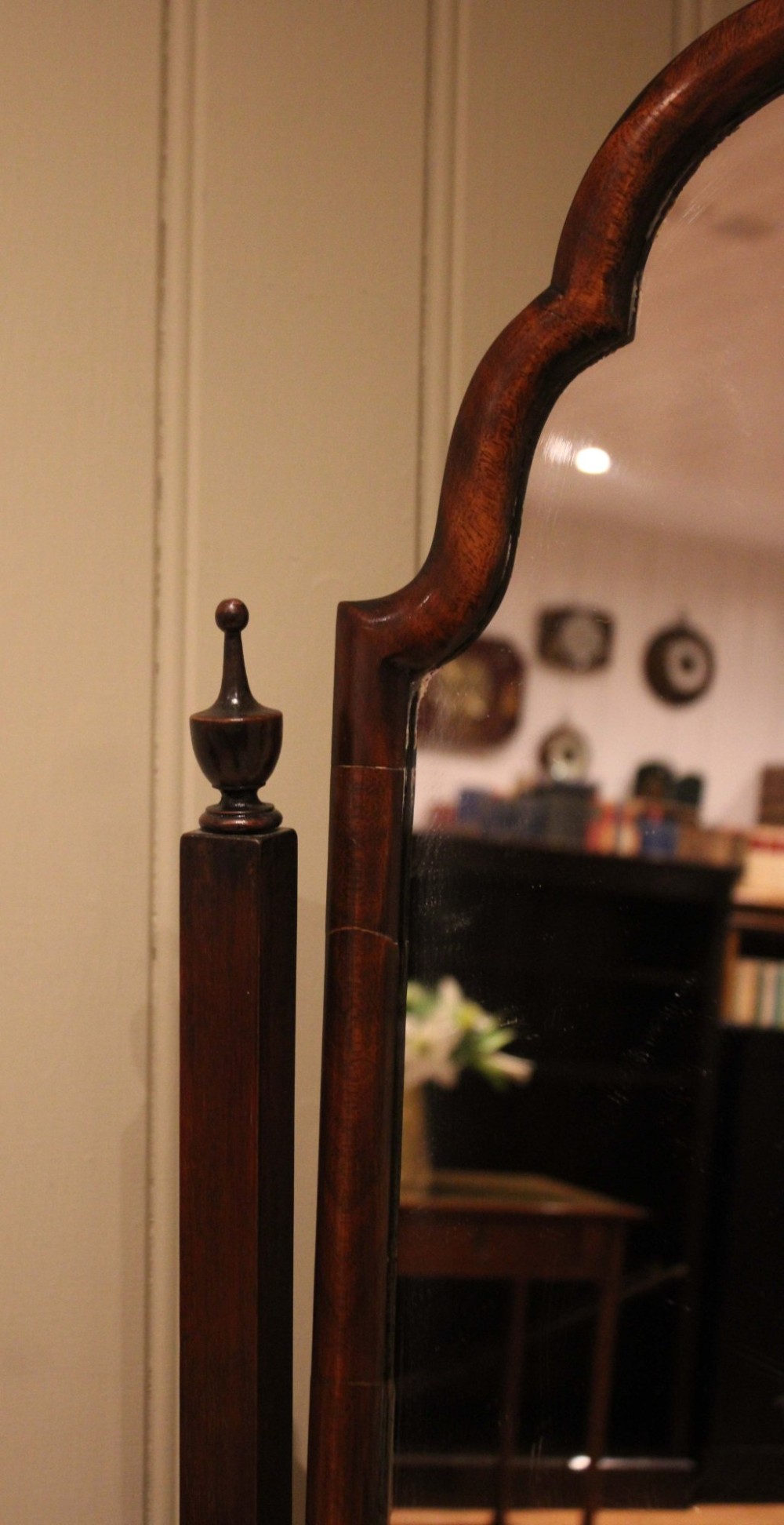 A mahogany cheval dressing mirror with an arched top frame, turned finials on the uprights, and splayed legs. View XI