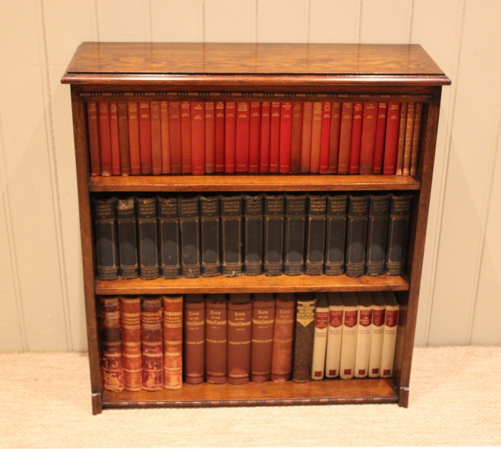 A low open oak bookcase in warm brown featuring three fixed shelves and subtle carved moulding along the top and base edges. View III