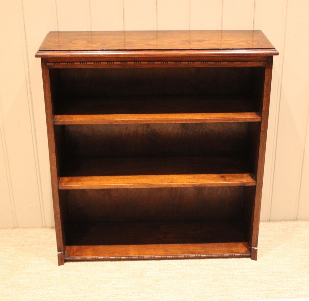 A low open oak bookcase in warm brown featuring three fixed shelves and subtle carved moulding along the top and base edges. View IV