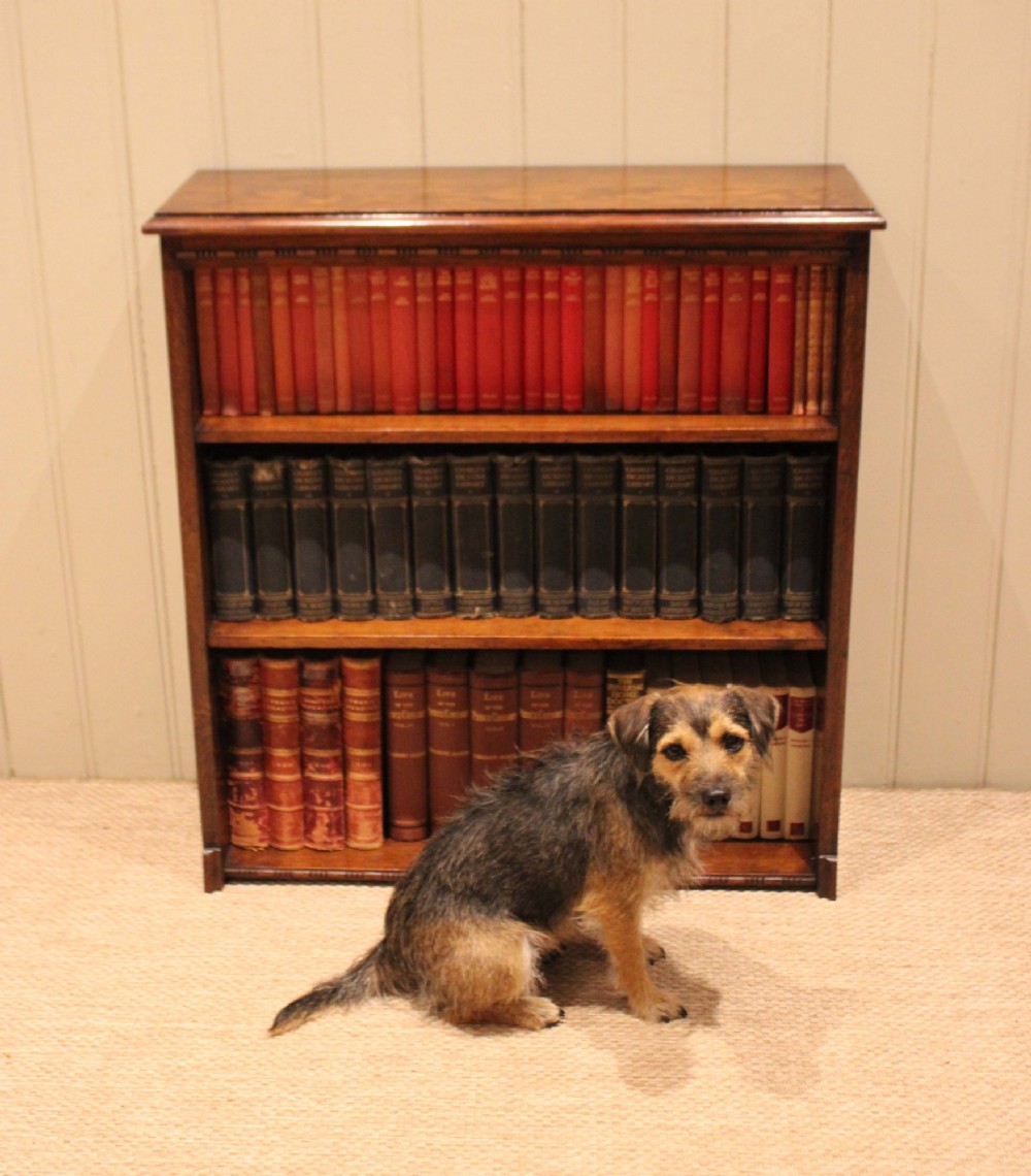 A low open oak bookcase in warm brown featuring three fixed shelves and subtle carved moulding along the top and base edges. View VII
