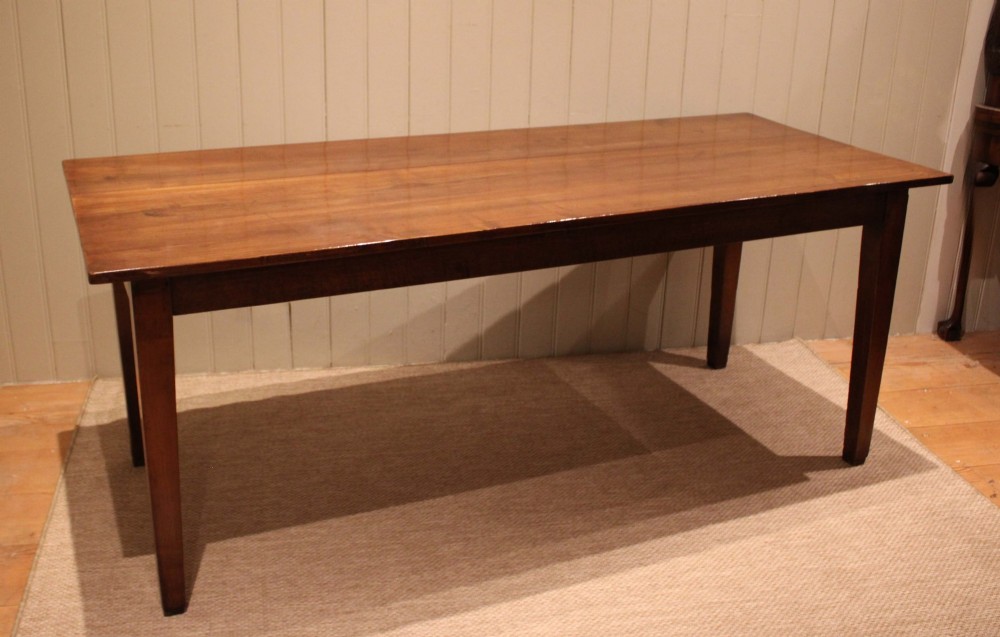 A large rectangular wooden farmhouse table made of chestnut and oak with a polished plank top and simple tapered square legs. View II
