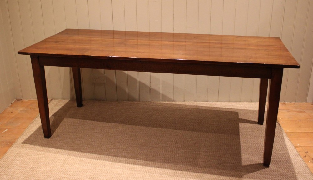 A large rectangular wooden farmhouse table made of chestnut and oak with a polished plank top and simple tapered square legs. View V