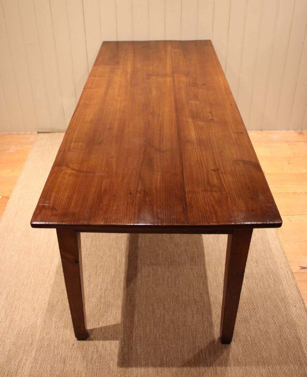 A large rectangular wooden farmhouse table made of chestnut and oak with a polished plank top and simple tapered square legs. View VI
