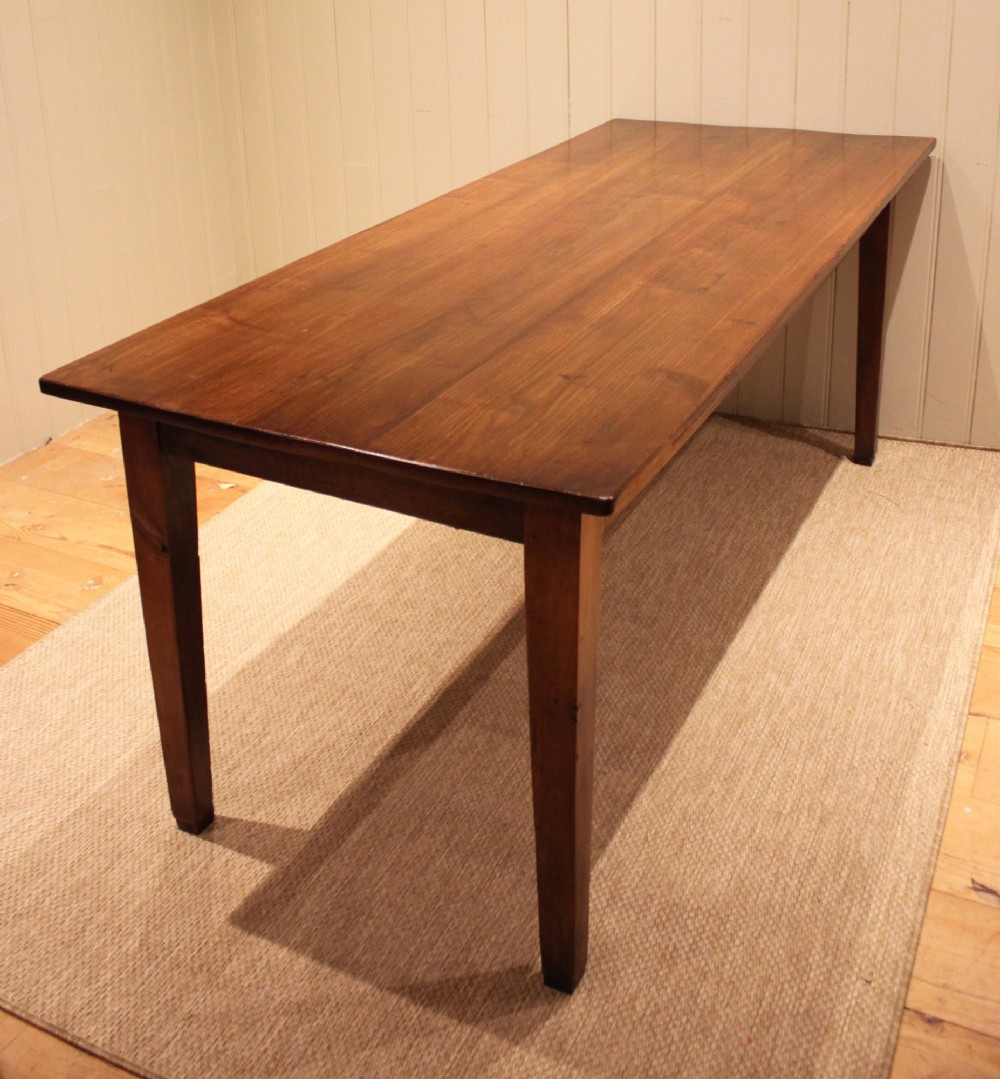A large rectangular wooden farmhouse table made of chestnut and oak with a polished plank top and simple tapered square legs. View VII