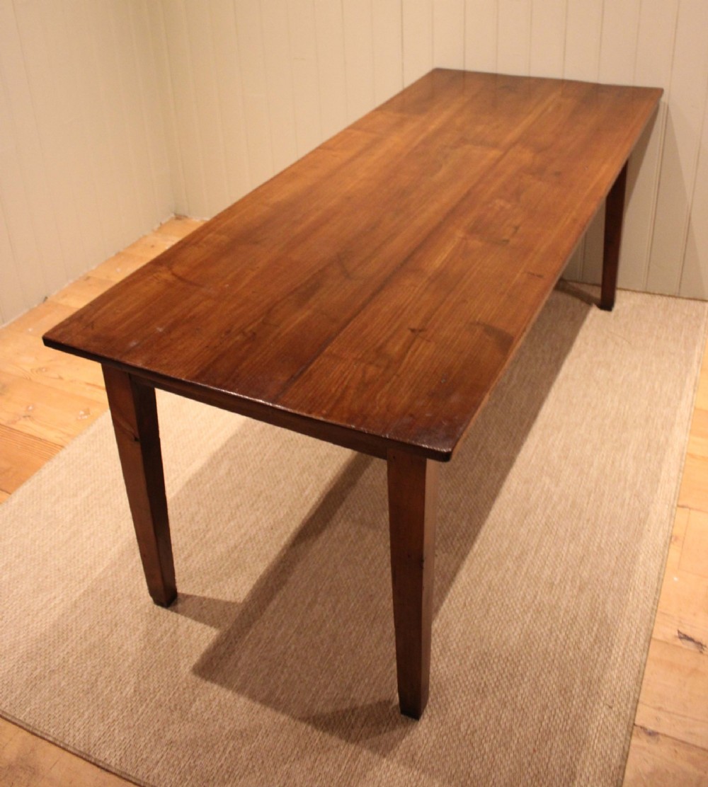 A large rectangular wooden farmhouse table made of chestnut and oak with a polished plank top and simple tapered square legs. View IX