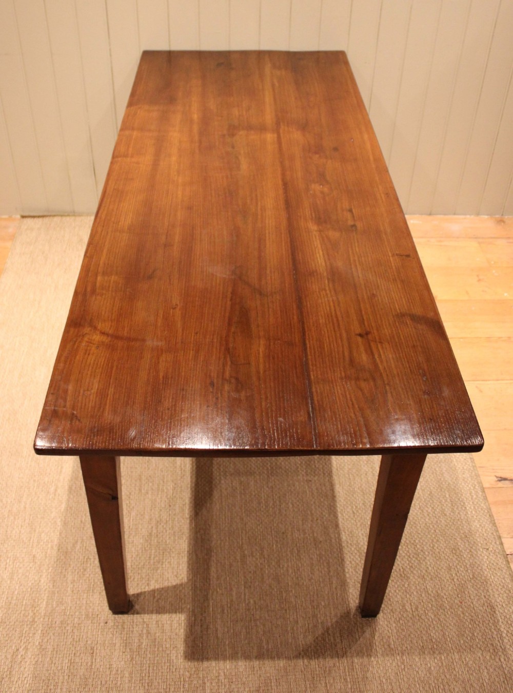 A large rectangular wooden farmhouse table made of chestnut and oak with a polished plank top and simple tapered square legs. View XII