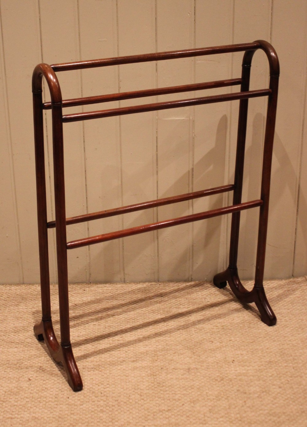 A late 19th-century mahogany freestanding towel rail featuring rounded upright arches, multiple horizontal crossbars, and curved trestle feet. View VII