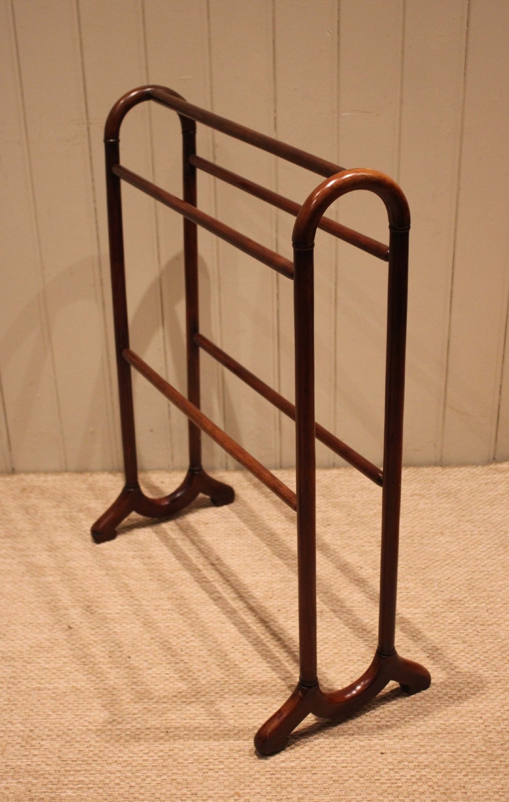 A late 19th-century mahogany freestanding towel rail featuring rounded upright arches, multiple horizontal crossbars, and curved trestle feet. View IX