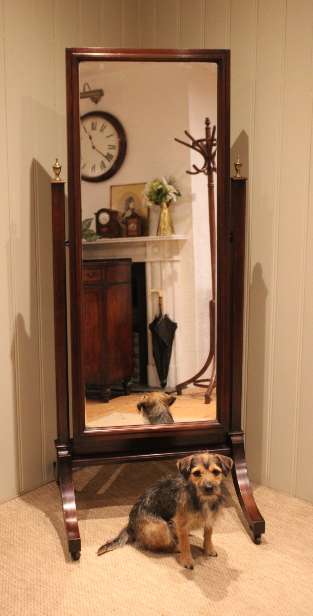 A late nineteenth-century mahogany cheval mirror featuring a rectangular swinging glass frame supported by upright pillars on splayed feet with brass castors. View IV