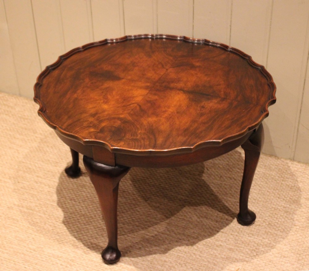 A low circular walnut table featuring a scalloped piecrust edge, quarter-veneered top surface, cabriole legs, and pad feet. View IV