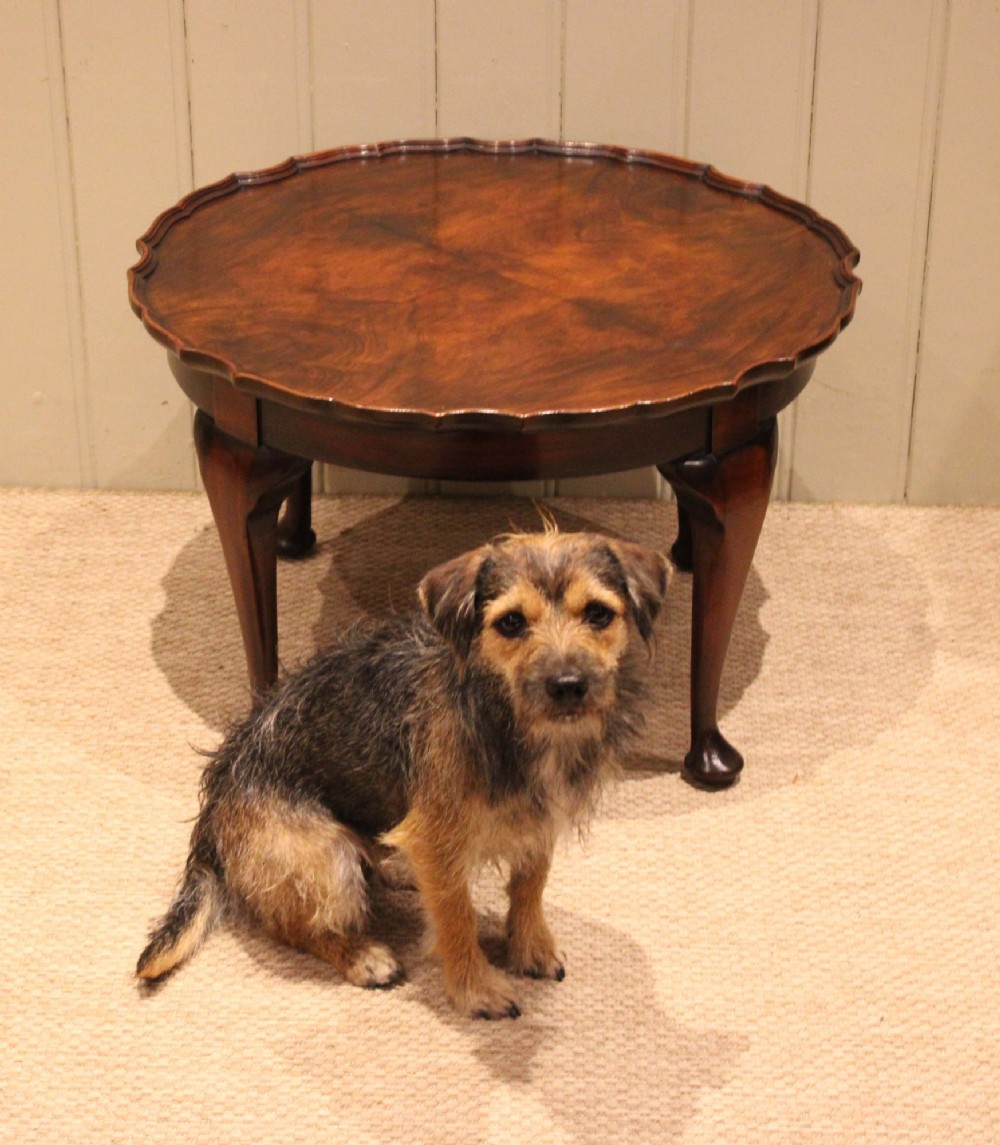 A low circular walnut table featuring a scalloped piecrust edge, quarter-veneered top surface, cabriole legs, and pad feet. View VII