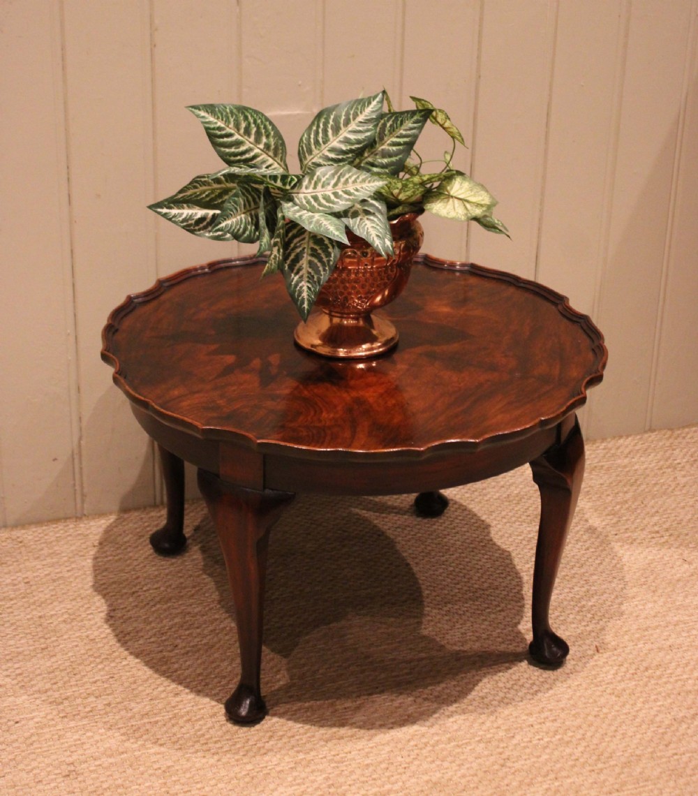 A low circular walnut table featuring a scalloped piecrust edge, quarter-veneered top surface, cabriole legs, and pad feet. View VIII