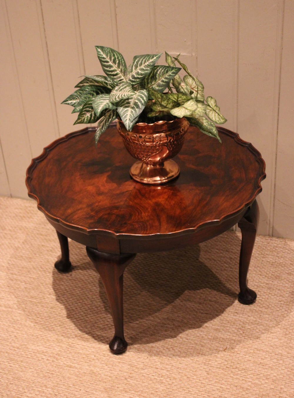 A low circular walnut table featuring a scalloped piecrust edge, quarter-veneered top surface, cabriole legs, and pad feet. View XI