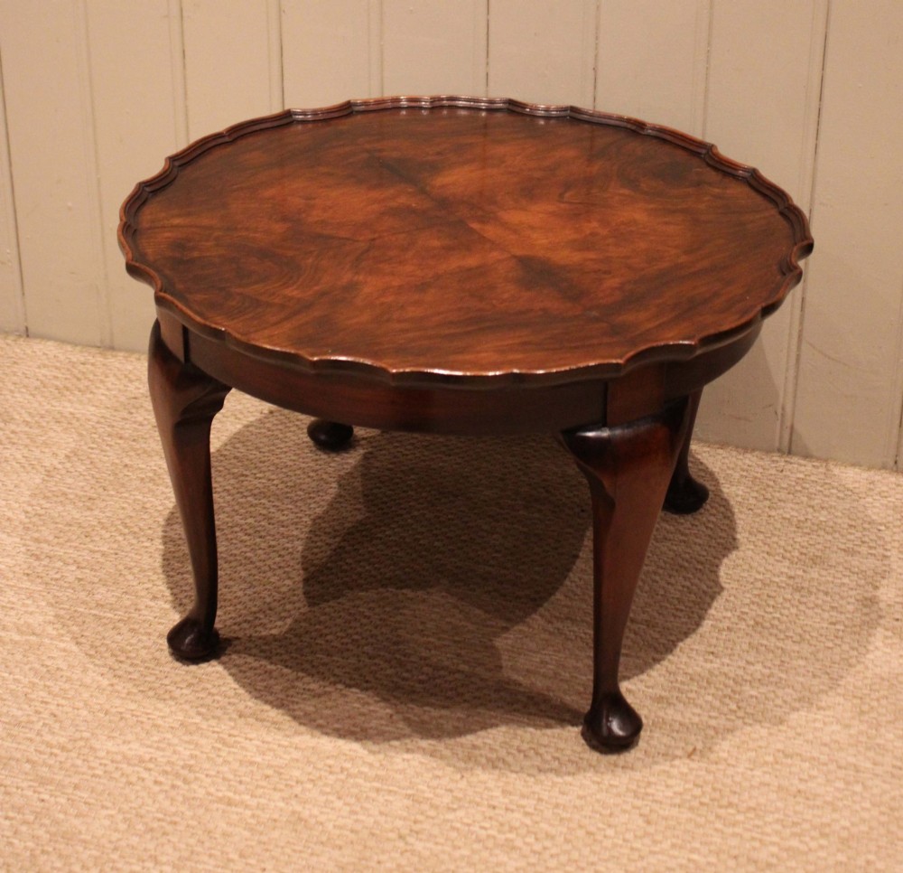 A low circular walnut table featuring a scalloped piecrust edge, quarter-veneered top surface, cabriole legs, and pad feet. View XII