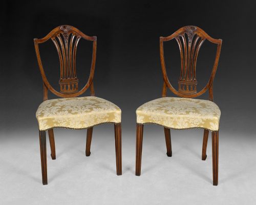 A Pair of Hepplewhite Period Mahogany Shield Back Side Chairs with Anthemion (Honeysuckle) Carved Detail