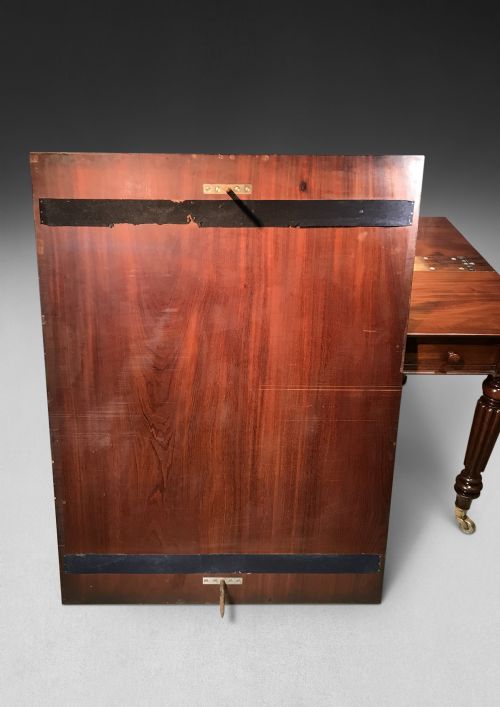 fig 2. A Regency mahogany draw-leaf dining table with extended leaves, reeded legs, and brass cup castors.