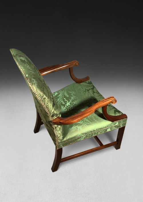 fig 3. A pair of Chippendale period Gainsborough armchairs with carved mahogany frames, scrolled arms, and green damask upholstery trimmed with brass studs.