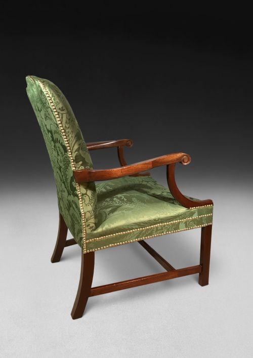 fig 4. A pair of Chippendale period Gainsborough armchairs with carved mahogany frames, scrolled arms, and green damask upholstery trimmed with brass studs.